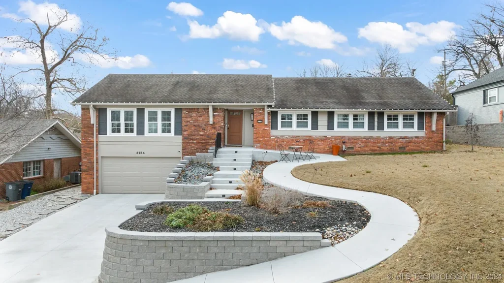 Front exterior view of a single-story brick ranch home with concrete driveway, steps, and curved walkway